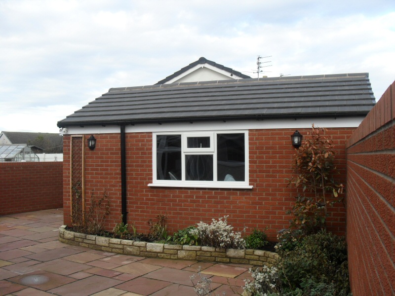 Photo - Garage and Landscaping (3 of 3) - View of the side of the garage with landscaping including raised beds with brick border and flagging. - Extensions - Home - © J C Joinery